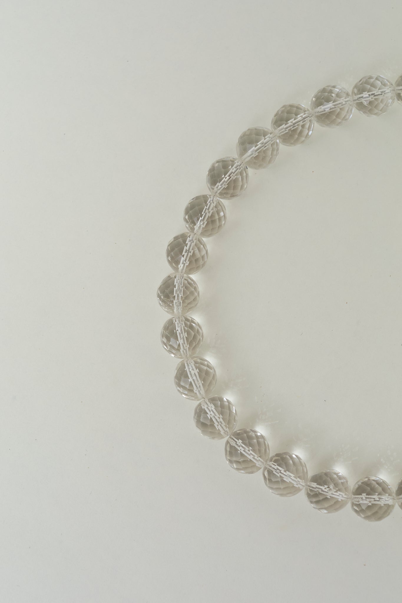 Transparent bead necklace with metallic thread
