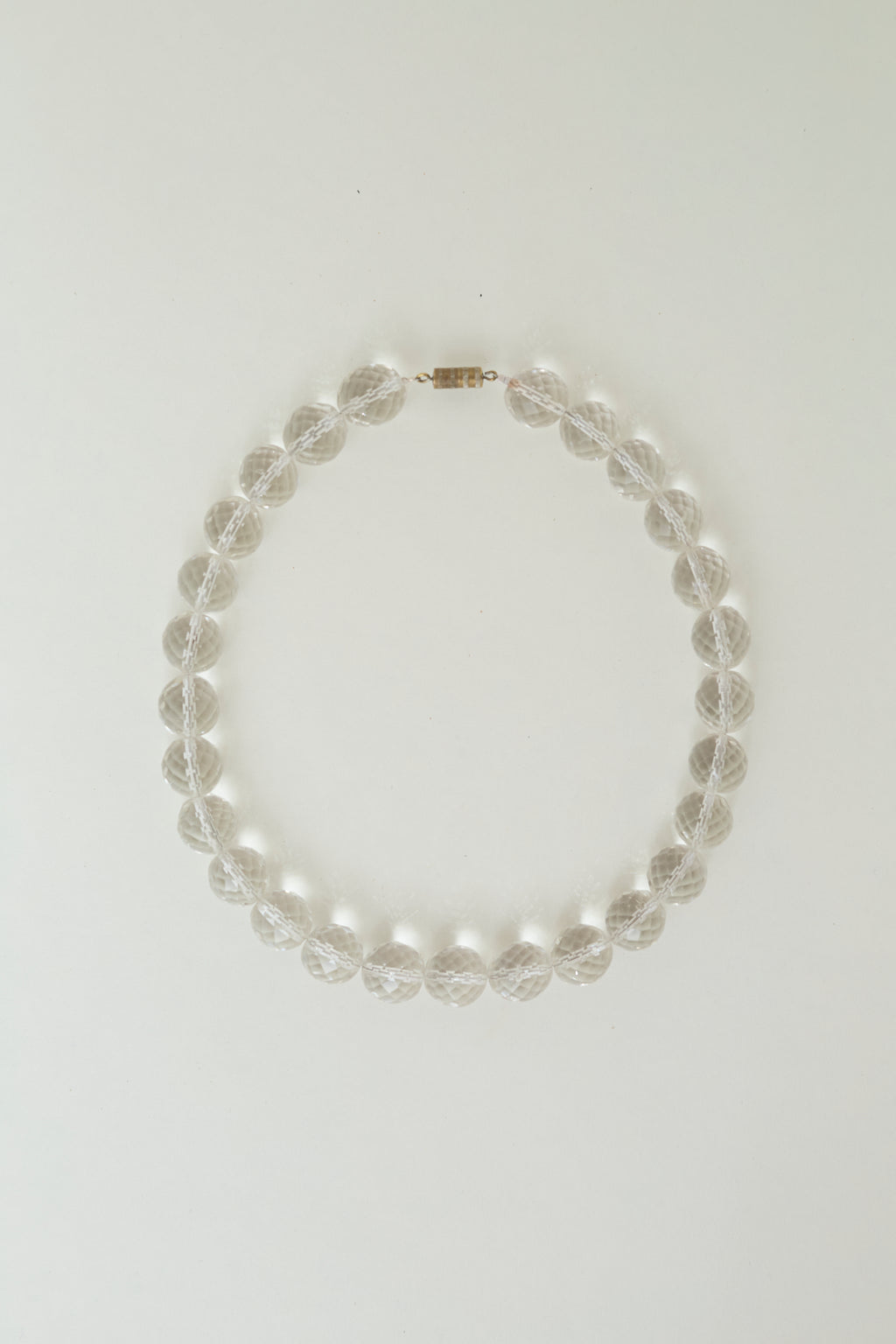 Transparent bead necklace with metallic thread