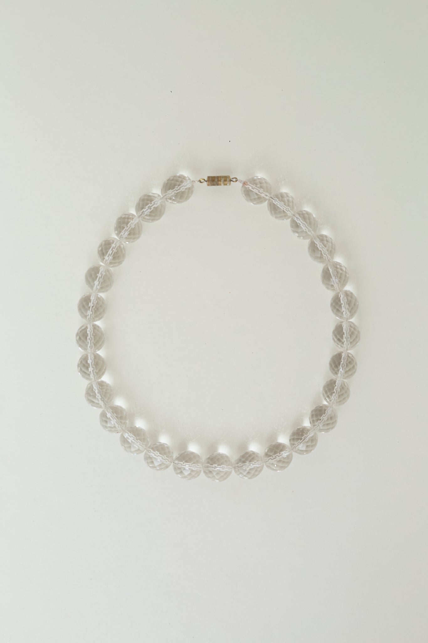 Transparent bead necklace with metallic thread