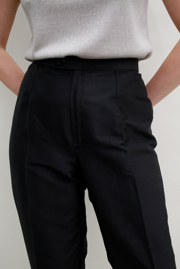 Close up of frontal part around hips of the black silk trousers on a model